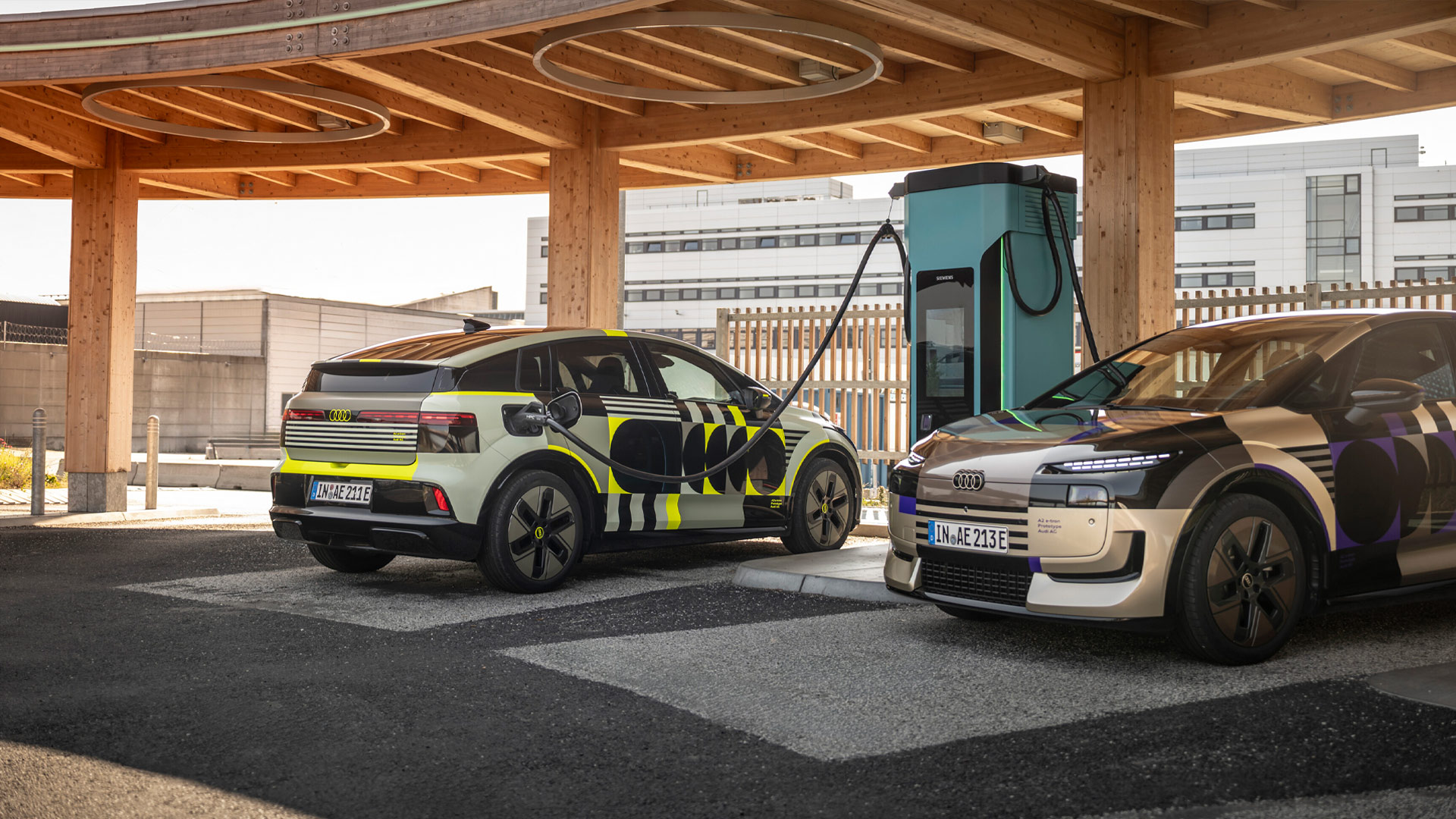 Outdoor-Standaufnahme zweier Audi A2 e-tron an einer Ladesäule