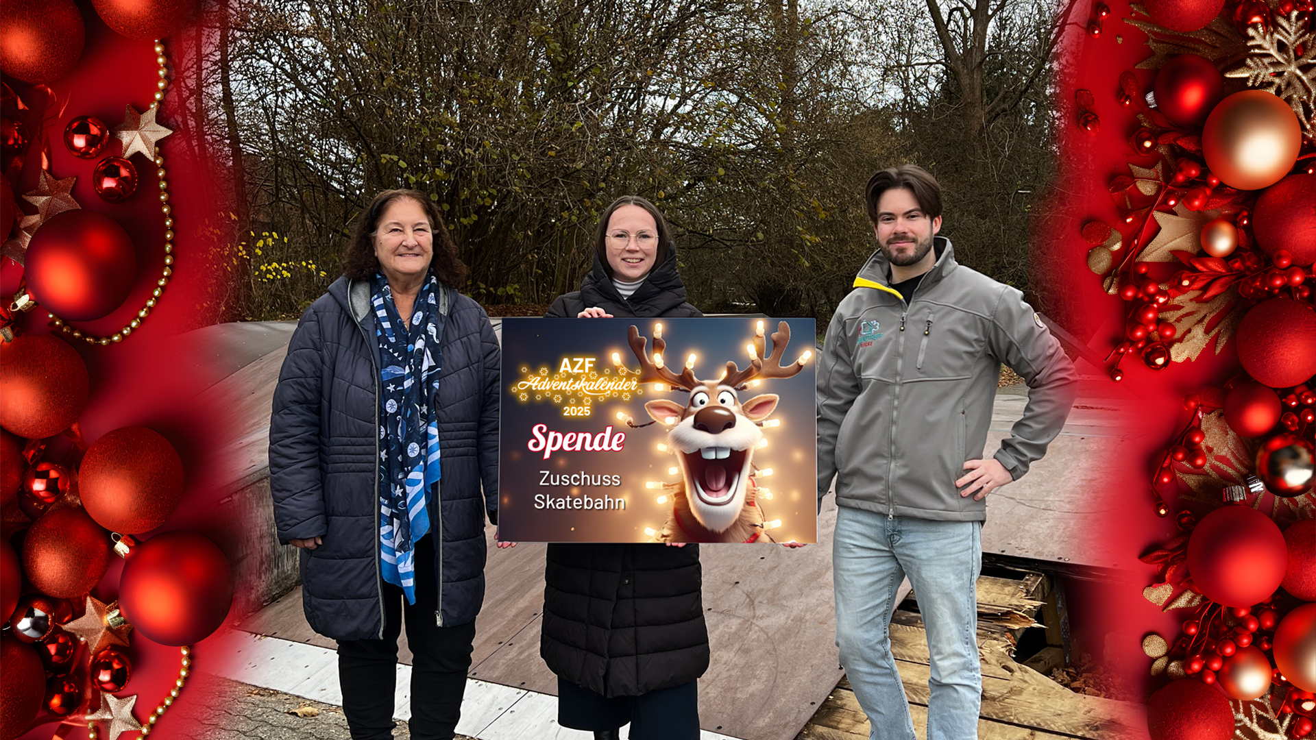 Drei Personen halten einenSpendencheck im Hintergrund befindet sich eine alte Skaterbahn
